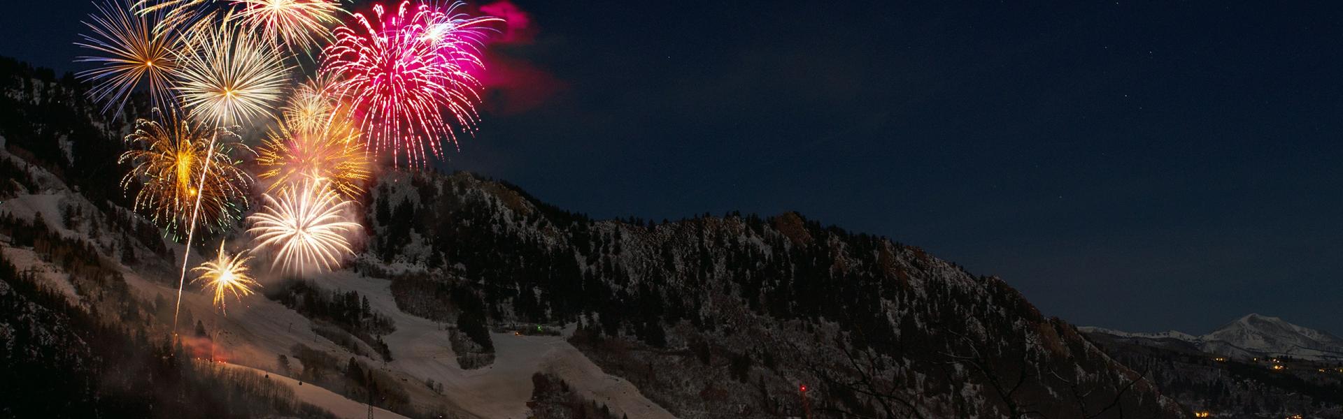 fireworks display from snow capped mountain during nighttime