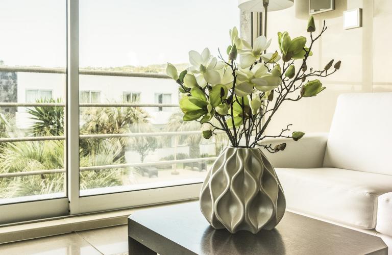 Moderne Vase mit Blumen auf Wohnzimmertisch