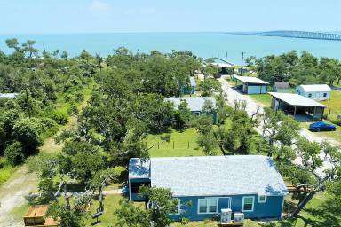 3 bedroom 2 bath nestled in the oak trees right on Copano Bay! Private Pier!