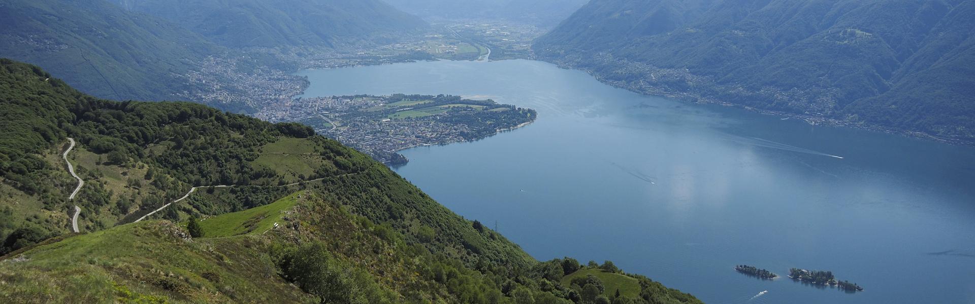 The Swiss side of Lake Maggiore on a sunny morning in May, seen from Porera, Monti di Ronco, near the cities of Locarno and Ascona. The cities of Locarno and Ascona are partly visible in the distance with the Maggia river delta.