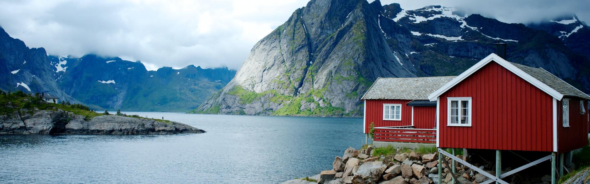 red and white wooden house in front of body of water