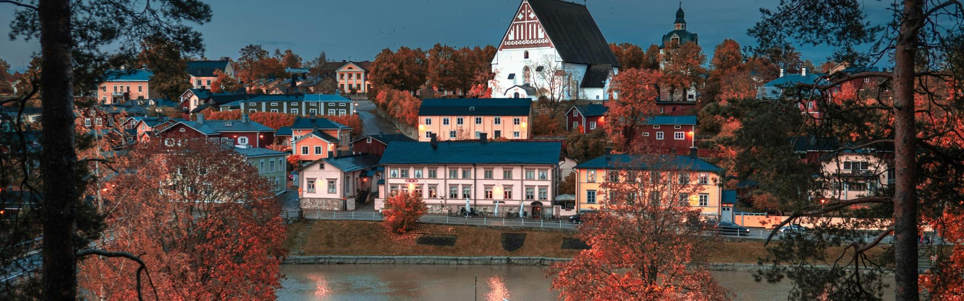 white concrete buildings beside body of water at night