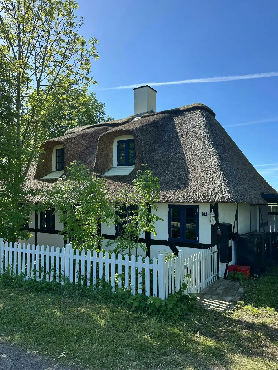 Stråtækt hus på Lolland med udsigt over markerne