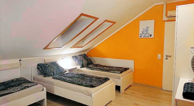 Dreibettzimmer mit Gemeinschaftskuche und je 2 Dusch und 2 Toilettenzimmern
