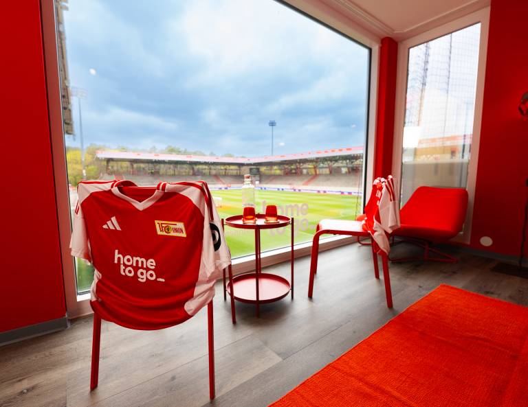 Fußballtrikot auf Stuhl, Blick auf Stadion durch Fenster. [Stadionnächte by HomeToGo] [Berlin]