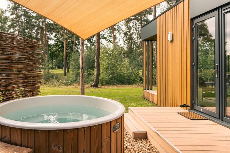 Wasser-Lodge mit Hot Tub am Wasser in Twente. Luxuriöse Lodge im Hofparken De Bergvennen mit wunderschönem Blick über den See, Terrasse und privatem Wellnessbereich.