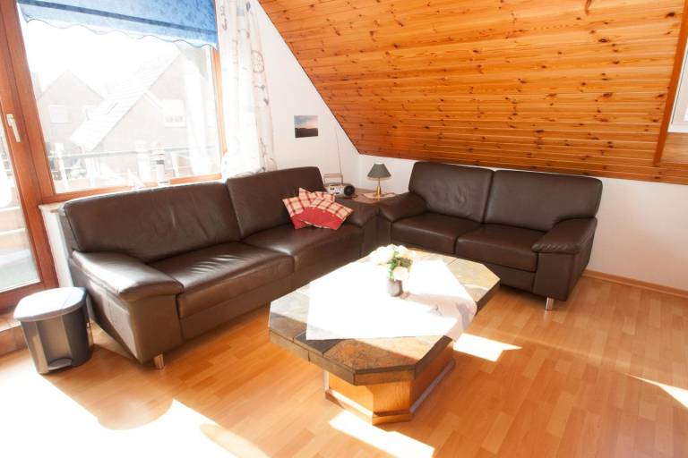 Wärme und Wohnlichkeit: Die Obergeschosswohnung stellt für 4 bis 5 Personen viel zur Verfügung. Auf dem großen Balkon lassen sich tolle Spieleabende ausrichten. — photo 4
