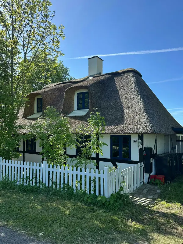 Stråtækt hus på Lolland med udsigt over markerne