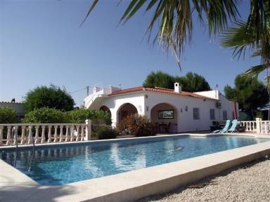 Villa im spanischen Stil mit großem Pool und eingezäuntem Grundstück, umgeben von Orangenplantagen